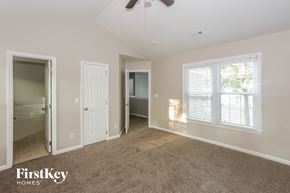 Charlotte house for rent - A spacious room with a carpeted floor and a ceiling fan.