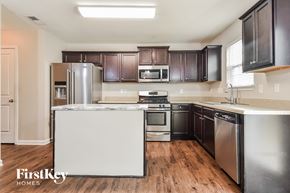 Greensboro house for rent - a kitchen with stainless steel appliances and dark wood cabinets