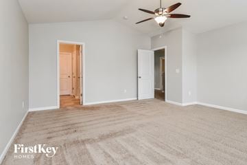 Greensboro house for rent - a spacious living room with carpet and a ceiling fan