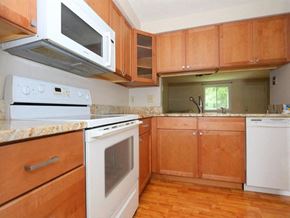Maineville house for rent - A kitchen with wooden cabinets and a white oven.