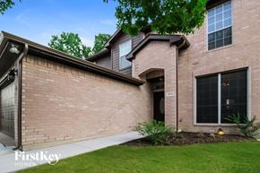 Little Elm house for rent - a side view of a brick house with a sidewalk and grass