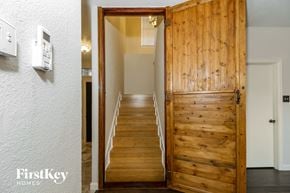 Little Elm house for rent - a wooden door opens up to a staircase in a house