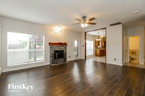 Little Elm house for rent - an empty living room with a fireplace and a ceiling fan