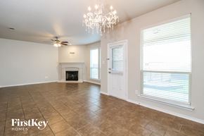 Fort Worth house for rent - A spacious room with a fireplace and a chandelier.