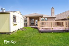 Fort Worth house for rent - A house with a yellow exterior and a wooden deck.