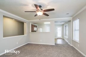 Spring house for rent - an empty living room with a ceiling fan and a kitchen