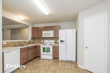 Spring house for rent - a kitchen with white appliances and wooden cabinets