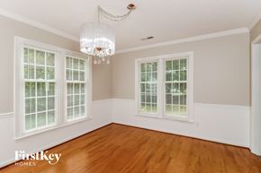 High Point house for rent - an empty dining room with windows and a chandelier