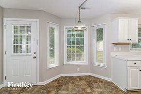 High Point house for rent - a kitchen with white cabinets and a sink and a window
