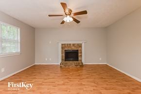 Lithonia house for rent - A room with a fireplace and a ceiling fan.