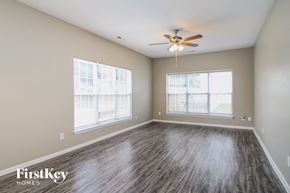High Point house for rent - A room with a ceiling fan and wood flooring.