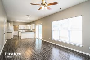 High Point house for rent - A spacious living room with a ceiling fan and hardwood floors.