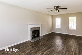 Concord house for rent - A spacious room with a fireplace and a ceiling fan.