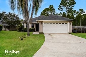 Jacksonville house for rent - a suburban house with a white garage door and a yard with ducks