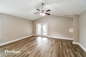 Jacksonville house for rent - an empty living room with hardwood flooring and a ceiling fan