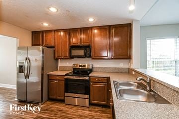 Jacksonville house for rent - a kitchen with stainless steel appliances and wooden cabinets