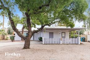 Phoenix house for rent - A tree in front of a white house with a sign that says "FirstKey Homes".