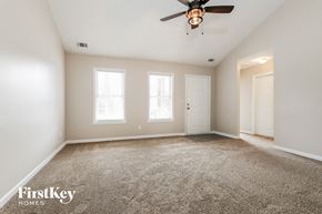 Winder house for rent - a spacious living room with carpet and a ceiling fan