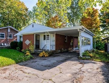 Guelph apartment for rent - A house with a red brick exterior and a white porch.