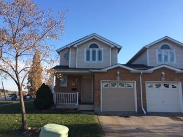 Guelph apartment for rent - A two-story house with a white garage door.