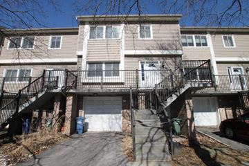 Guelph apartment for rent - the front of an apartment building with stairs and a garage