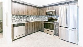 Margate apartment for rent - a kitchen with stainless steel appliances and wooden cabinets