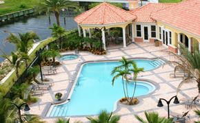 Palmetto house for rent - a large swimming pool in front of a house with palm trees