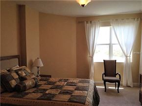 Palmetto house for rent - a bedroom with a bed and a chair and a window