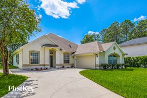 Jacksonville house for rent - a white and yellow house with a driveway and grass