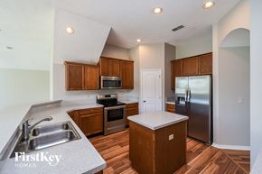 Jacksonville house for rent - a kitchen with wooden cabinets and stainless steel appliances