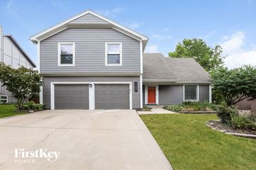 Overland Park house for rent - a blue house with a driveway and a garage door