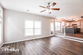 Overland Park house for rent - an empty living room with a ceiling fan and a kitchen