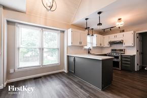 Overland Park house for rent - a kitchen with white and black cabinets and a large window