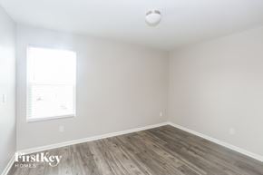 Midland house for rent - a bedroom with white walls and wood floors and a window