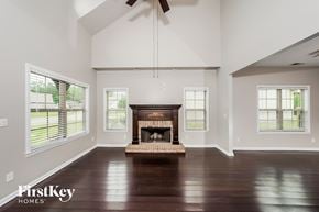 Odenville house for rent - A large, empty room with a fireplace and wooden floors.
