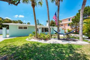 Holmes Beach house for rent - A house with a hammock between two trees.