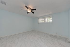 Holmes Beach house for rent - A room with a ceiling fan and a window with blinds.