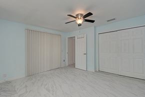Holmes Beach house for rent - A room with a ceiling fan and three doors.