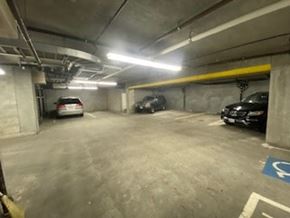 San Francisco apartment for rent - A parking garage with a white car and a black car parked in it.