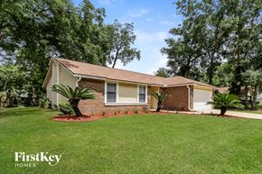 Jacksonville house for rent - a small brick house with a lawn and palm trees
