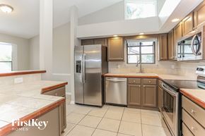 Jacksonville house for rent - a kitchen with wooden cabinets and stainless steel appliances