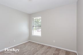 Jacksonville house for rent - a bedroom with white walls and carpet and a window