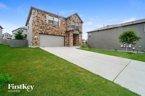San Antonio house for rent - a white driveway in front of a brick house with a garage