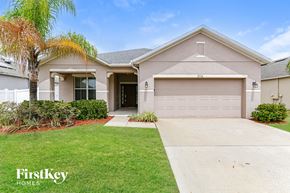 Kissimmee house for rent - A house with a garage and a driveway in front of it.