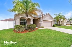 Kissimmee house for rent - A house with a palm tree in front of it.