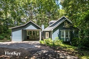 Loganville house for rent - a blue house with a driveway and a garage door