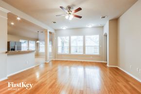 Spring house for rent - A spacious room with wooden floors and a ceiling fan.