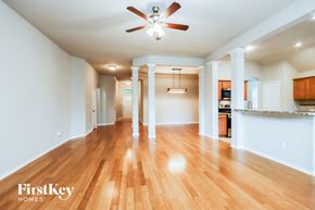 Spring house for rent - A spacious room with wooden floors and a ceiling fan.