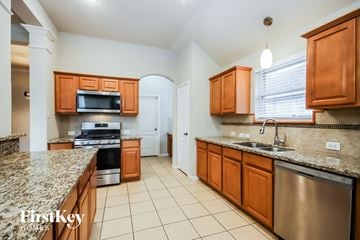 Spring house for rent - A kitchen with brown cabinets and granite countertops.