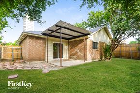 Balch Springs house for rent - a small brick house with a porch and a grassy yard